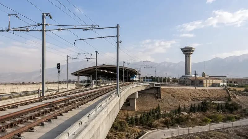 خط ریل روباز با شبکهٔ برق هوایی و سایبان ایستگاه در ادامهٔ مسیر